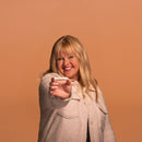 Woman holding a smartphone against a brown background