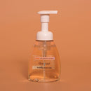 Foaming hand soap bottle with pump on a brown background