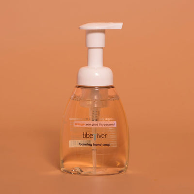 Foaming hand soap bottle with pump on a brown background