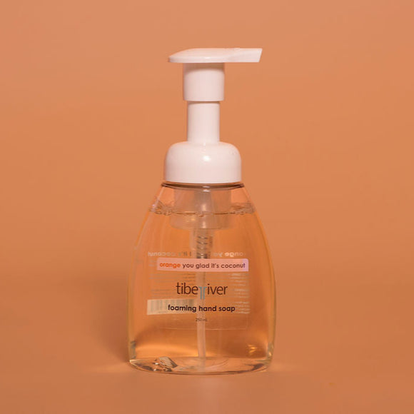Foaming hand soap bottle with pump on a brown background