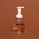 Foaming hand soap bottle with pump on a brown background