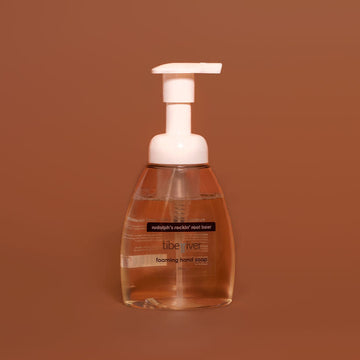 Foaming hand soap bottle with pump on a brown background