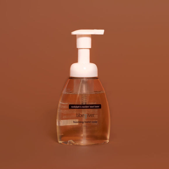 Foaming hand soap bottle with pump on a brown background