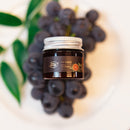Jar of lip scrub on a plate with grapes and leaves