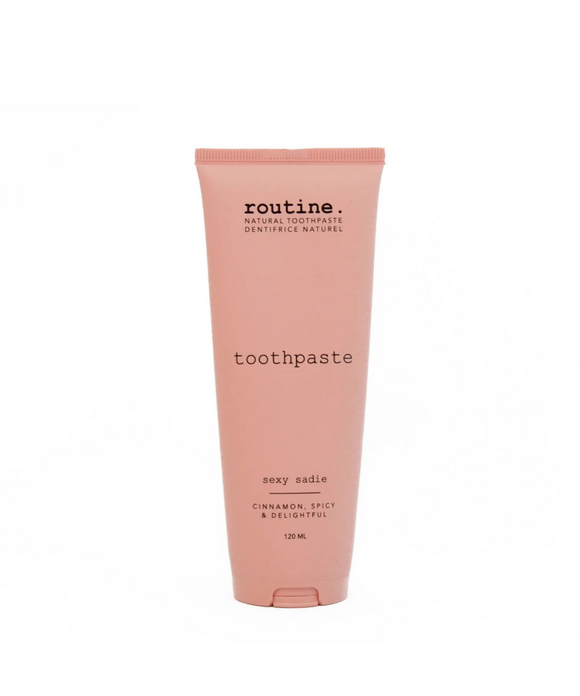 A pink tube of Routine brand toothpaste labeled 'Sexy Sadie' with cinnamon flavor, emphasizing natural ingredients.