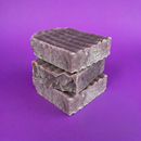 Three stacked soap bars on a purple background