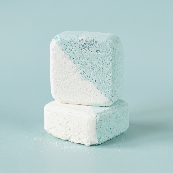 Two stacked bath bombs with a gradient of blue to white on a light blue background