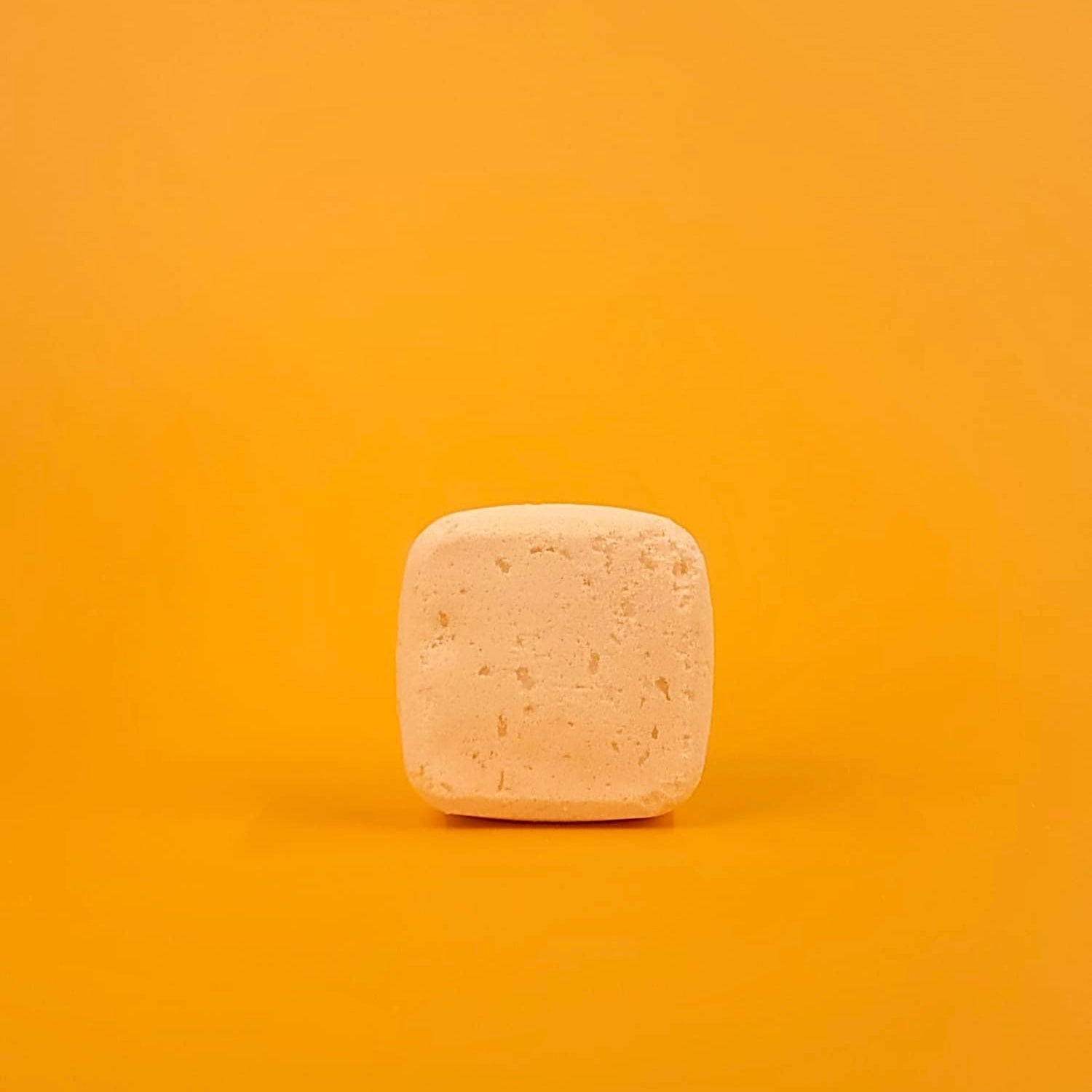 Square bar of soap on a gradient orange background