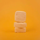 Three stacked soap bars on a yellow background