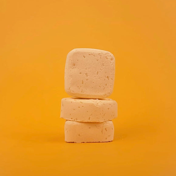 Three stacked soap bars on a yellow background