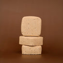 Three stacked root beer scented bath bomb squares on a brown background